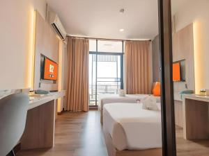 a hotel room with two beds and a window at B2 Khamtieng Boutique & Budget Hotel in Chiang Mai