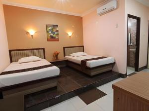 deux lits assis dans une chambre avec salle de bain dans l'établissement Patria Palace Hotel, à Blitar 90 autres photos