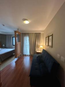 a living room with a couch and a bed at Hotel Estanpla Moema Ibirapuera com garagem piscina 1004 in Sao Paulo +35 photos