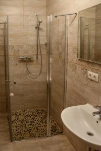 um chuveiro com uma porta de vidro ao lado de um lavatório em Holiday Terrace Nida em Nida
