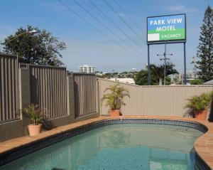 uma piscina com um sinal para um motel com vista para o parque em Park View Motel em Gladstone
