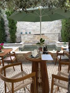 a table with a green umbrella on a patio at Eleven, Boutique luxury house & garden in Boliqueime