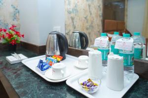 a bathroom counter with two plates of food and bottles of water at Hotel Zain Grande Chennai in Chennai