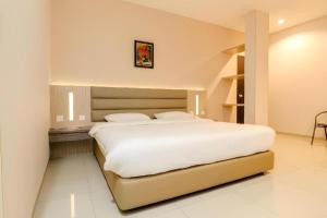 a bedroom with a large white bed in it at Lovina Inn Hotel Batam in Nagoya +220 photos