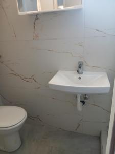 a bathroom with a white sink and a toilet at Ž apartmani in Zadar +8 photos