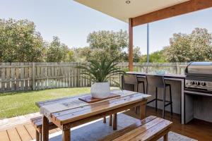 a patio with a wooden table and a grill at LJ's Hideout in Dunsborough