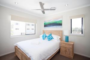 1 dormitorio blanco con 1 cama y 2 ventanas en Petrie Beach Holiday Home, en Mackay