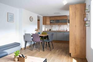 a living room and kitchen with a table and chairs at Vila Jelena - modern spacious apartments near Vintgar Gorge & Bled in Zgornje Gorje
