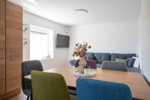 a dining room with a table with chairs and a couch at Vila Jelena - modern spacious apartments near Vintgar Gorge & Bled in Zgornje Gorje