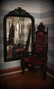 a chair and a mirror in a room at Hotel Doña Luisa in San Luis de Sabinillas