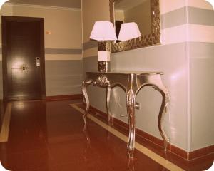 a room with a table with a lamp and a mirror at Hotel Doña Luisa in San Luis de Sabinillas