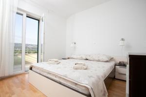 a white bedroom with a bed and a large window at Villa Luna in Imotski +35 photos