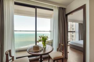 ein Hotelzimmer mit einem Tisch und Meerblick in der Unterkunft Mandala Sunrise Escape in Mui Ne