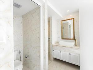 ein weißes Badezimmer mit Waschbecken und Spiegel in der Unterkunft B2 Hua Hin Premier Hotel in Hua Hin + 85 Fotos