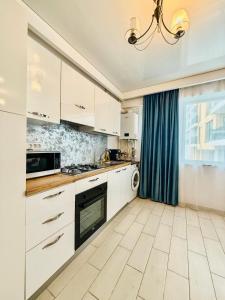a kitchen with white cabinets and a window at Apartament 2 camere Mamaia Nord in Mamaia Nord