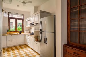 a kitchen with a refrigerator and a checkered floor at La Morena, Newly Constructed Luxurious 4 BHK villas in Assagao, Private Pool, Balcony, Kitchen, Patio, Security in Assagao