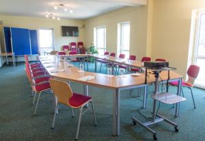 einen Konferenzraum mit einem langen Tisch und Stühlen in der Unterkunft Landhotel Rittersgrün in Breitenbrunn