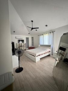 Un dormitorio con una cama y un ventilador de techo. en Villa TSJ LUXURY, en Tamarin