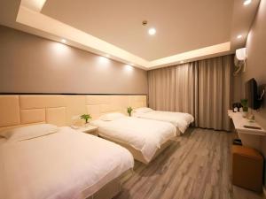 two beds in a hotel room with white sheets at Shell Jiaxing Nanhu District Dongsheng Dong Road Moon River Street Hotel in Jiaxing