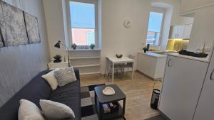 a living room with a couch and a kitchen at Studio Gea in Semedela