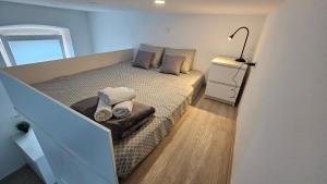 a small bedroom with a bed in a room with a lamp at Studio Gea in Semedela