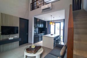 Una cocina y una sala de estar con una mesa. en Casa de la Vida, en Tanah Lot