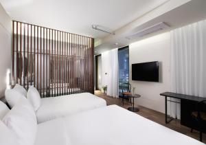 a bedroom with two beds and a desk and a television at Park Marine Hotel in Incheon