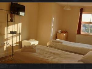 a hotel room with two beds and a window at OYO The Watermans Arms Hersham in Hersham