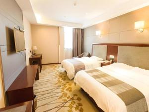 a hotel room with two beds and a flat screen tv at GreenTree Alliance Disneyland North Gate in Shanghai