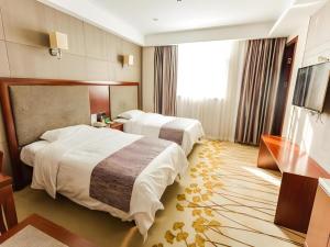 une chambre d'hôtel avec deux lits et une télévision dans l'établissement GreenTree Alliance Disneyland North Gate, à Shanghai