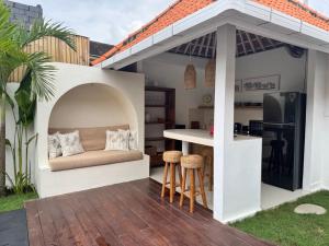 a patio with a couch under a pavilion at Villa Kuu - Elegant 2BR Villa with Private Pool in Kerobokan