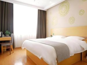 a bedroom with a large white bed and a desk at GreenTree Inn Express Gongqing City Nanchang University in Gongqingcheng +55 photos