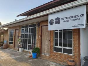 a brick building with a sign for a guest house at CuteHomes KB in Kota Belud
