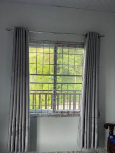 a window with curtains in a white room with at feel like home in Pokhara