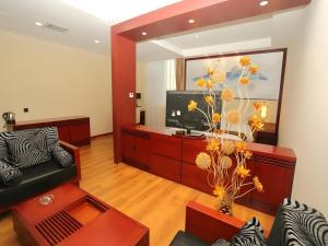 a living room with a couch and a television at GreenTree Eastern Yantai Development Zone Zhujiang Road Hotel in Yantai