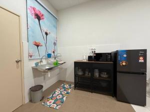 a small kitchen with a sink and a refrigerator at Hillside Homestay by UmmiSya in Tampin