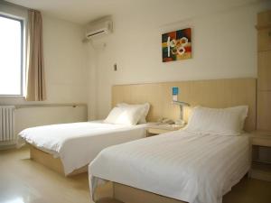 a hotel room with two beds and a window at Jinjiang Inn Qingdao International Exhibition Center Haier Road in Qingdao +212 photos