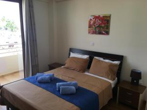 ein Schlafzimmer mit einem großen Bett mit blauen Handtüchern darauf in der Unterkunft Ithaki Phinikoudes Apartment No. 205 in Larnaka