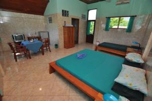a bedroom with a blue bed and a living room at Tulamben Wreck Divers Resort & Restaurant in Tulamben +129 photos