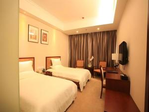 a hotel room with two beds and a desk at GreenTree Inn Rizhao Haiqu East Road Hotel in Rizhao