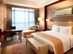 a hotel room with a large bed and a desk at GreenTree Inn Rizhao Haiqu East Road Hotel in Rizhao