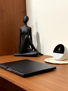 图卢姆Experience the charm of Tulum, a unique loft in Aldea Zama的一位女士坐在桌子上，手里拿着笔记本电脑的雕像