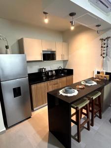 图卢姆Experience the charm of Tulum, a unique loft in Aldea Zama的配有冰箱和桌椅的厨房