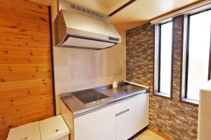 una cocina con fregadero y estufa en Sumiyoshi Kaze Home, en Osaka