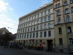 a large stone building on a city street at Orange Cat Rooms in Riga