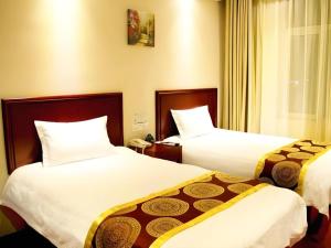 a hotel room with two beds and a window at GreenTree Inn Heze Mudan Road Bus Terminal Station Express Hotel in Heze