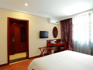 a bedroom with a bed and a desk and a television at GreenTree Inn Hefei Chenghuangmiao San Xiao Kou Subway Station Hotel in Hefei