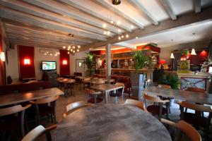 a restaurant with wooden tables and chairs in a room at Logis Le Bourguignon in Bèze