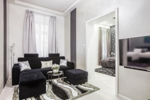 a living room with a black couch and a mirror at Opera Luxory Suite in Budapest