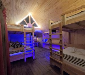 a room with three bunk beds in a cabin at Gisban Wood Cabana & Hostel in Habarana
